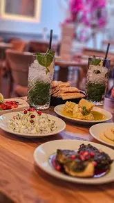 A montage showcasing the interior, drinks, and a variety of Turkish small plates at Table Five by Cappadocia, highlighting the fresh ingredients and vibrant atmosphere.