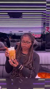 A creator visits Rassams Creamery in Manchester, showcasing the extensive dessert menu, the robot server, and the vibrant, neon-lit interior. The video features a review of their waffles and crepes, highlighting the indulgent nature of the food.