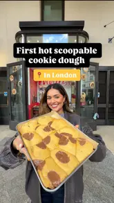 The video features a creator showcasing a new 'hot scoopable cookie dough' product from Blondies Kitchen in London. It demonstrates the product's texture, the serving process with ice cream and toppings, and the creator's reaction to eating it.