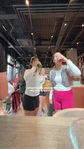A group of women in athletic wear are filmed during a morning run and subsequent social gathering at a cafe, where they enjoy green juices and cookies. The video focuses on the camaraderie and the 'day in the life' experience of a running club.