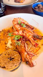 A couple visits an Italian restaurant, showcasing the exterior, the pizza oven, various dishes including prawns, arancini, pizza, and ravioli, and the overall dining experience with their baby.