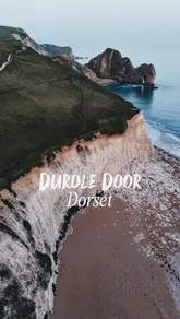 A cinematic drone montage showcasing the dramatic limestone arch and coastal scenery of Durdle Door on the Jurassic Coast, Dorset.