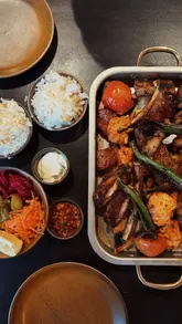 A montage-style video showcasing a Turkish restaurant called KÖZLE, featuring shots of the exterior, interior, various mezze dishes, a mixed grill platter, cocktails, and dessert.