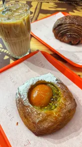 The video features a montage of various pastries, breads, and cakes in a display case at Jolene bakery, followed by a shot of the creator eating a pastry and drinking coffee, set to music with text overlays.