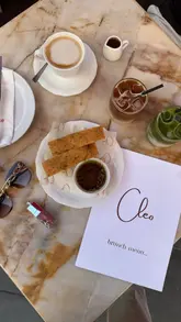 A short, aesthetic montage showcasing a brunch experience at Cleo in Belgravia, featuring close-ups of coffee, matcha, pasta with burrata, salad, and fluffy pancakes.