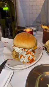 A video review of a Filipino-European bistro in London, featuring a variety of dishes including cured scallops, tempura cod, steak tartare, and a mushroom rice dish, alongside cocktails. The creator provides commentary on the food and the overall dining experience.