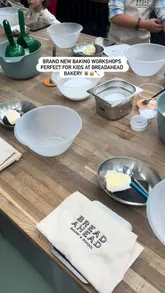 A short video showcasing a children's baking workshop at Bread Ahead Bakery, featuring kids mixing dough and preparing scones.