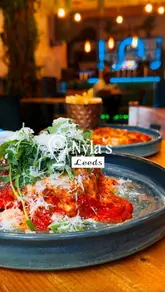 A short, polished montage featuring close-up shots of food, including lasagna and steak, alongside cocktails and interior shots of the restaurant Nyla's in Leeds.