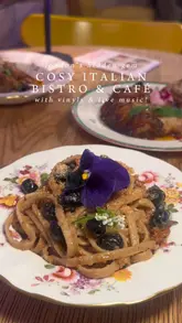 A short, aesthetic montage showcasing Malavenda Cafe & Bistro in London. The video highlights the venue's unique selling point—a large collection of vinyl records for sale and listening—alongside close-up shots of traditional Calabrian dishes like aubergine meatballs, struncatura pasta, and homemade chocolates. The editing is rhythmic and clean, focusing on the cozy, intimate atmosphere of the space.