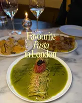 A top-down shot of three pasta dishes on a marble table in a dimly lit restaurant setting, featuring a candle and wine glasses. The image is used to promote pasta recommendations in London.