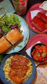 A promotional reel for Wonderlust Bistro in Oldham, showcasing a variety of dishes including steak sandwiches, pasta, Korean corn dogs, and desserts, alongside glimpses of the venue's interior.