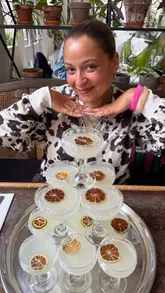 A creator visits Bourne & Hollingsworth Buildings in Clerkenwell to review their brunch menu, specifically highlighting the new bottomless margarita tower. The video features shots of the venue's interior, the menu, and close-ups of dishes like Huevos Benedictus and pancakes, accompanied by a voiceover and text overlays.