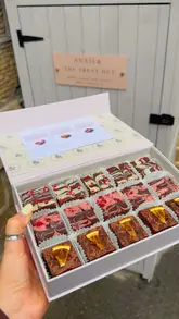 The video features a creator visiting a 'Treat Hut' in Farsley to collect a box of artisanal brownies. It combines personal vlog-style footage of the journey and the pickup process with close-up, high-quality shots of the various brownie flavours, showcasing the presentation and the unique nature of the bakery's collection service.