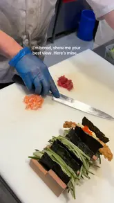 A short, static video showing a chef assembling sushi tacos at a restaurant. The focus is entirely on the preparation process, highlighting the fresh ingredients and the assembly technique.