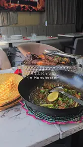 A short promotional video for Butt Karahi in Manchester, featuring close-up shots of their mixed grill, lamb karahi, and naan, interspersed with brief glimpses of the restaurant's interior decor.