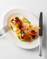 A professionally captured, high-end culinary dish featuring roasted native lobster, tempura lobster claw, aioli, bisque, and caviar, presented with meticulous plating on a white plate.