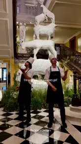 A polished promotional video showcasing a collaboration between Claridge's Hotel and The Newt Somerset, featuring wicker animal sculptures, apple-themed decor, cookies, coffee, and bottled drinks within the hotel lobby.