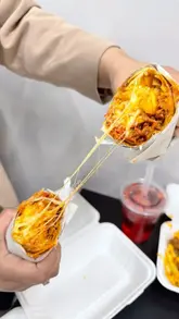 A short, punchy video showcasing various takeaway items from Flamez, including a double cheeseburger, chicken tikka pizza, a special wrap with a cheese pull, and loaded fries. The video relies on close-up, handheld shots of the food to highlight textures and ingredients.