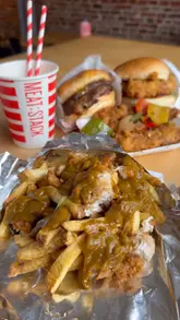 A fast-paced food review video showcasing the new 'Spice Bag' menu series at Meat Stack, featuring close-ups of burgers, loaded fries, chicken tenders, and a milkshake.