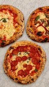 A short, engaging video showcasing the process of making Neapolitan-style pizza at a backyard pop-up venue. It follows the journey from the alleyway entrance to the dough preparation, baking in a portable oven, and the final product.
