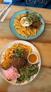 A video review of a plant-based Portuguese restaurant in Bristol, featuring a variety of dishes including croquettes, peri-peri chicken alternatives, and a pastel de nata. The creator shares her thoughts on the texture and taste of the plant-based meat substitutes.
