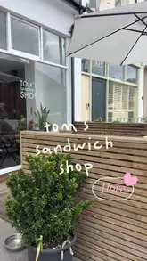 A short, personal review of Tom's Sandwich Shop in Hove, highlighting the menu and specific sandwich orders like the New York pastrami and Cajun chicken baguette.