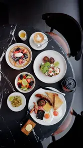 A short, visually focused reel showcasing a breakfast spread at Bread Street Kitchen, located on the 59th floor of 22 Bishopsgate. The video highlights the panoramic views of London alongside a variety of breakfast dishes, including pancakes, fruit salad, avocado toast, and a full English breakfast.