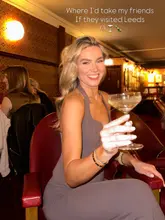 A portrait of a woman holding a cocktail in a dimly lit bar, presented as a recommendation for a night out in Leeds.