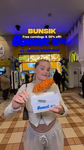 A couple visits the newly opened Bunsik at the Trafford Centre, showcasing the ordering process at the kiosk and sampling a variety of Korean street food items including corn dogs, fried chicken, katsu curry, and kimmari.