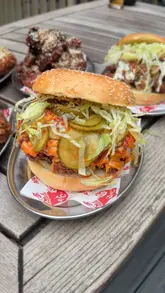 A fast-paced review of 'Around The Cluck', a fried chicken pop-up located at the Old Fountain pub in London. The creator showcases various dishes including burgers, tenders, and wings, highlighting the quality of the food and the chef's background. The video features a mix of talking-head segments, close-up shots of food preparation, and enthusiastic taste tests.