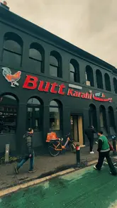 A montage of various Pakistani dishes including a BBQ platter, lamb karahi, and naan, followed by a brief shot of the restaurant's interior featuring a fireplace.