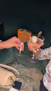 A short montage featuring two women enjoying cocktails and small plates at Tigerlily in Edinburgh, showcasing the venue's interior and menu offerings.