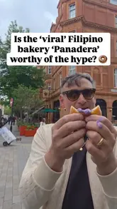 Two creators visit a Filipino bakery called Panadera in Marylebone to review their viral items, including a doughnut, a sausage roll, and a cinnamon roll. They provide honest, conversational feedback on the taste and quality of each item while walking around the area.