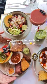 A short, visually appealing montage showcasing a variety of brunch dishes, including shakshuka, pancakes, and fresh salads, at a London cafe. The video uses close-up, handheld shots to highlight the presentation and textures of the food.