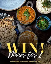 A flat-lay photograph of an Indian meal featuring curries, rice, and naan bread, used to promote a giveaway for a dinner for two.