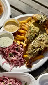 A short, punchy review of a piri-piri chicken street food vendor, featuring close-ups of the cooking process, the finished dishes, and the creator tasting the food.