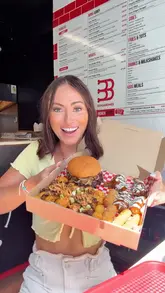 A high-energy, vlog-style review of a 'munch box' from Buns & Bones in Aldershot. The creator showcases the variety of food included, such as a smash burger, wings, tots, mozzarella sticks, and a brownie, while highlighting the value for money. The video features close-up shots of the food, the cooking process, and the creator's genuine reactions.
