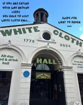 A clear, well-composed architectural shot of the White Cloth Hall in Leeds, used as a cover image for a social media post. The image effectively captures the venue's exterior, utilizing natural light and a clean composition to invite viewers to visit.