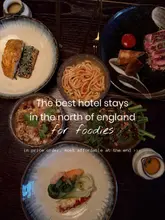 A flat-lay overhead shot showcasing a spread of Asian-fusion dishes, likely from a hotel restaurant. The image uses a dark, moody aesthetic to convey an upscale dining experience.