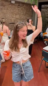 A lively, vlog-style reel showcasing a bottomless brunch experience at PizzaExpress. The video features the creator and friends enjoying drinks, food, and the venue's atmosphere, which includes a live DJ and dancing.