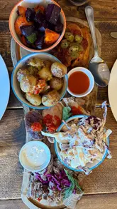 A montage showcasing a Sunday BBQ sharing feast at Little Piggy, featuring close-ups of various meats, sides, and desserts.