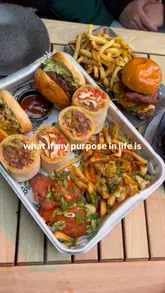 A fast-paced montage video showcasing a variety of food dishes, drinks, and hospitality venue interiors, including restaurants, bars, and an arcade/games area. The video uses a 'what if my purpose in life is...' text overlay to frame the experience as a series of indulgent treats.