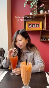 A couple enjoys a meal at a Thai restaurant, showcasing various dishes including pork wontons, grilled pork, pad see ew, and mango sticky rice.