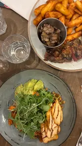 A montage video showcasing a variety of dishes from The Refinery, including steak, small plates like meatballs and pork belly, gnocchi, and pizza, along with a brief exterior shot of the venue.