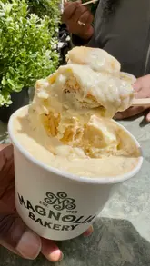 A creator visits the Magnolia Bakery pop-up at Café Ciel in London, reviewing their famous banana pudding and limited-edition sticky toffee pudding. The video captures the experience of visiting the stall, the menu options, and the creator's genuine enjoyment of the dessert, while highlighting the limited-time nature of the pop-up.