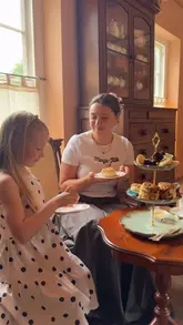 A short, pleasant video documenting a family visit to a cafe for an afternoon tea service. The footage captures the arrival, the table setting, the tea pouring, and the enjoyment of the scones and sandwiches.