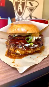A promotional video for a burger restaurant showcasing new menu items, including a voting process for customers to choose their favorite burger.