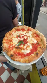 A fast-paced, energetic vlog documenting a launch party at a new Pizza Pilgrims venue. The video features the creators trying various pizzas, drinks, and desserts, while showcasing the lively atmosphere, DJ, and interior of the restaurant.