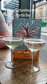 The video features a creator at Turtle Bay enjoying a bottomless brunch. They use a 'spin the wheel' app on their phone to randomly select cocktails from the menu, adding an interactive element to the review. The video showcases various food dishes, cocktails, and the restaurant's interior atmosphere.