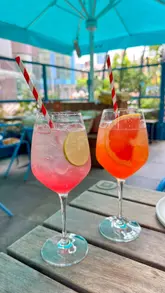 A short, handheld-style reel showcasing new summer menu items and cocktails at a Wahaca restaurant. The video features close-up shots of spritz cocktails, a tostada, and a chipotle-glazed aubergine dish, ending with a shot of the venue's outdoor seating area.